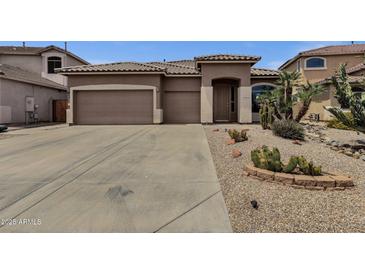 Charming single-story home with desert landscaping and a spacious three-car garage at 34944 N Mirandesa Dr, San Tan Valley, AZ 85143