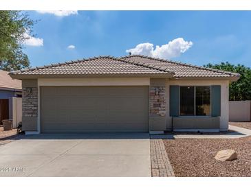 Charming single-story home featuring a tile roof, stone accents, and a two-car garage in a residential neighborhood at 4143 E Sundance Ave, Gilbert, AZ 85297