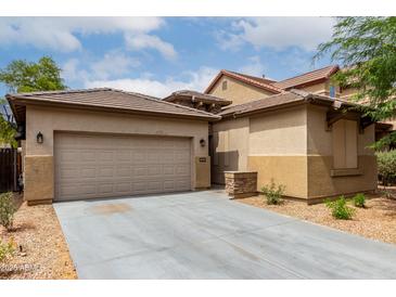 Inviting exterior showcasing a beige home with a two-car garage, complemented by a well-maintained concrete driveway at 8848 W Cordes Rd, Tolleson, AZ 85353
