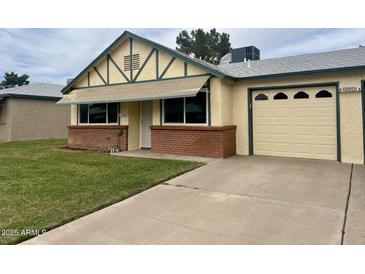 Charming single-story home with a brick accent wall and a well-manicured front lawn and a single car garage at 10201 N 97Th Ave # B, Peoria, AZ 85345