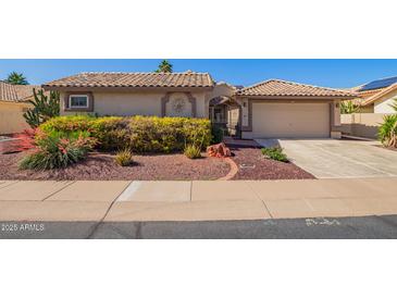 Charming single-story home featuring a tile roof, desert landscaping, and an attached two-car garage at 14390 W Morning Star Trl, Surprise, AZ 85374