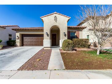 Charming single-story home featuring an arched entryway, desert landscaping, and an attached two-car garage at 20496 W Valley View Dr, Buckeye, AZ 85396