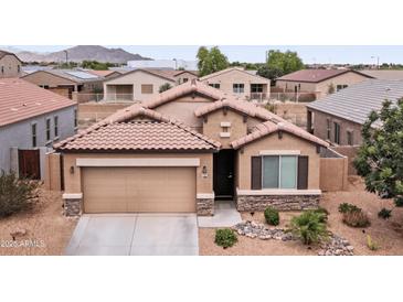 Charming single-Gathering home featuring a two-car garage, desert landscaping, and a tile roof in a residential neighborhood at 23690 W Ripple Rd, Buckeye, AZ 85326