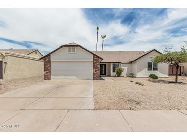 Charming single-story home with a two car garage and low maintenance desert landscaping in front at 11021 N 55Th Dr, Glendale, AZ 85304