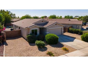 Charming single-story home featuring a tile roof, low-maintenance landscaping, and an attached two-car garage at 13170 W Clarendon Ave, Litchfield Park, AZ 85340