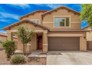 Charming two-story home featuring a well-manicured front yard, covered porch, and attached two-car garage at 15551 W Poinsettia Dr, Surprise, AZ 85379