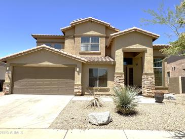 Inviting home featuring stone accents, a two-car garage, and low-maintenance desert landscaping in front yard at 33506 N 24Th Dr, Phoenix, AZ 85085