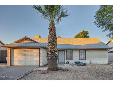 Charming single-story home featuring a low maintenance desert front yard, palm tree, and attached garage at 7222 W Maryland Ave, Glendale, AZ 85303