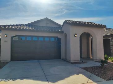 Charming single-story home with a tile roof, arched entry, and two-car garage under a bright blue sky at 9137 W Sells Dr, Phoenix, AZ 85037