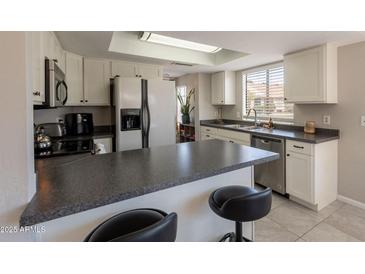 Bright kitchen features modern appliances, breakfast bar, and ample cabinet space at 2455 E Broadway Rd # 115, Mesa, AZ 85204