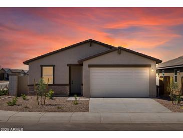 Charming single-story home featuring a two-car garage and desert landscaping against a beautiful sunset backdrop at 3557 E Audrey Dr, San Tan Valley, AZ 85143