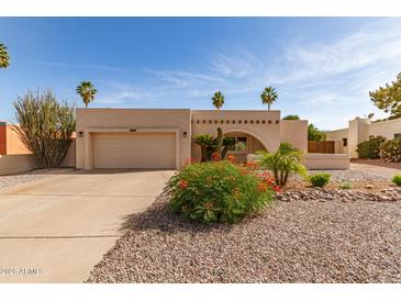 Charming single-story home featuring desert landscaping, an archway entrance, and an attached two-car garage at 4527 E Sunrise Dr, Phoenix, AZ 85044