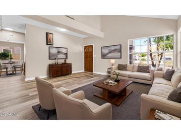 Spacious living room with vaulted ceilings, neutral tones, and modern wood flooring, perfect for entertaining at 6837 S Roosevelt St, Tempe, AZ 85283