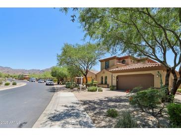 Beautiful two story house with tile roof, landscaping, and a view of the mountains in the distance at 9845 E Edgestone Dr, Scottsdale, AZ 85255
