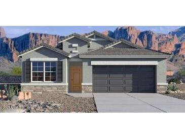 Charming single-story home showcasing desert landscaping, a two-car garage and shutters at 10516 W Bloch Rd, Tolleson, AZ 85353