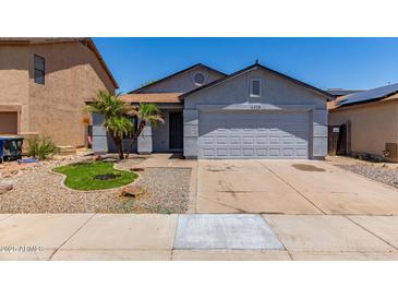 Charming single-story home features a two-car garage, desert landscaping, and mature palm trees at 11538 W Windrose Ave, El Mirage, AZ 85335