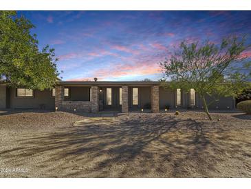 Charming single-story home with stone accents, desert landscaping, and walkway leading to the front entrance at 12423 N 64Th St, Scottsdale, AZ 85254