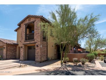 Two-story home with a stone facade, balcony, and well-maintained landscaping at 17665 N 93Rd Way, Scottsdale, AZ 85255