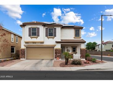 Charming two-story home featuring a two-car garage, landscaped yard, and solar panels for energy efficiency at 18222 W Lundberg St, Surprise, AZ 85388