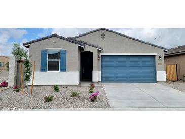Charming single-story home with blue garage door, blue shutters and low maintenance landscaping at 19390 N Fiano Dr, Maricopa, AZ 85138