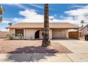 Charming single-story home with a front yard featuring desert landscaping and an attached carport at 2551 E Harmony Ave, Mesa, AZ 85204