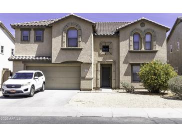 Inviting two-story home with a neutral-toned exterior, arched windows, attached two-car garage, and well-kept landscaping at 25574 W Lynne Ln, Buckeye, AZ 85326