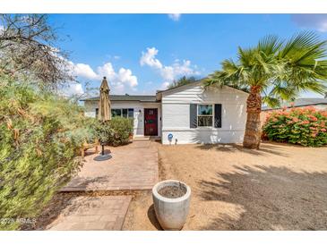 Charming single-story home featuring a red-accented entry, mature landscaping and a beautiful palm tree at 2801 N 10Th St, Phoenix, AZ 85006
