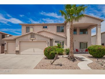 Charming two-story home boasts a well-manicured front yard, two-car garage, and a welcoming front porch at 43228 W Knauss Dr, Maricopa, AZ 85138