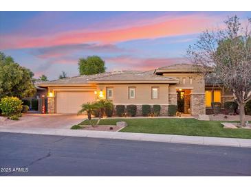 Beautiful single-story home featuring manicured landscaping, a paver driveway, and a two-car garage at sunset at 5291 S Bradshaw Pl, Chandler, AZ 85249