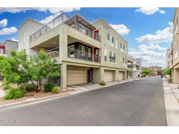 Contemporary three-story condo building with multiple balconies and attached garages at 1250 N Abbey Ln # 206, Chandler, AZ 85226