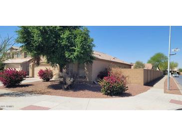 Charming single-Gathering home with a well-maintained front yard featuring colorful bushes and a mature tree at 2202 S 82Nd Ave, Phoenix, AZ 85043