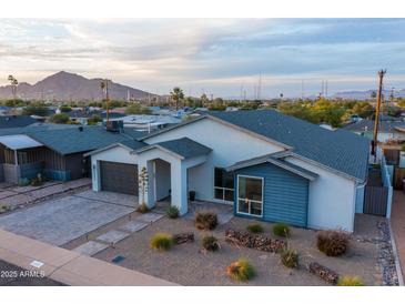 Contemporary home featuring a well-manicured desert landscape and mountain views at 6450 E Vernon Ave, Scottsdale, AZ 85257