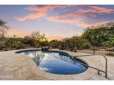 Inviting pool featuring beautiful stone surround and waterfall feature surrounded by desert landscaping at 7304 E Bent Tree Dr, Scottsdale, AZ 85266