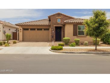 Charming home showcasing a blend of neutral stucco and stonework, complemented by a tile roof and landscaped front yard at 9757 E Red Giant Dr, Mesa, AZ 85212
