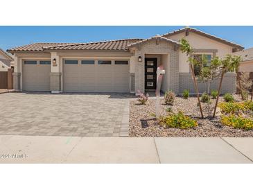 Charming home with a two-car garage, stone accents, and manicured landscaping at 12381 W Marguerite Ave, Avondale, AZ 85323
