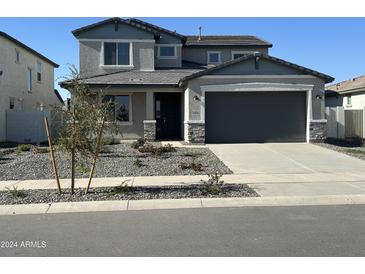 Two-story home with gray stucco, stone accents, gray garage door and desert landscaping at 12816 N 172Nd Dr, Surprise, AZ 85388