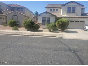 View of a charming two-story home with a well-manicured lawn and an attached two-car garage at 14150 W Boca Raton Rd, Surprise, AZ 85379