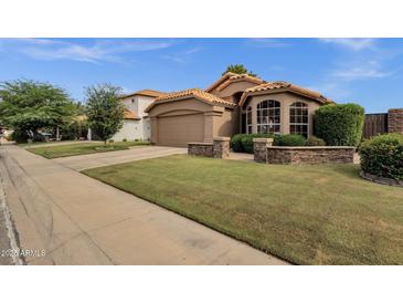 Charming home with a well-manicured lawn, attractive landscaping, and a stylish terracotta-tiled roof at 1558 W Maplewood St, Chandler, AZ 85286