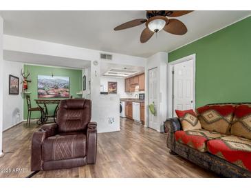 Inviting living room featuring stylish furniture, wood floors, and a peek into the dining area and kitchen at 16602 N 25Th St # 204, Phoenix, AZ 85032