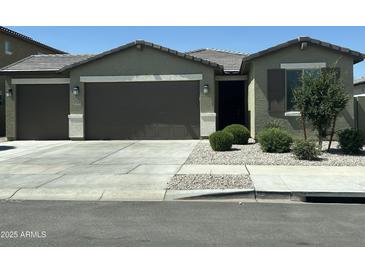 Charming single-story home featuring a two-car garage, desert landscaping, and neutral color palette at 17312 W Dahlia Dr, Surprise, AZ 85388