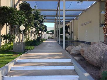 Scenic covered walkway with stone details and manicured landscaping leading to property amenities at 4411 N 40Th N St # 37, Phoenix, AZ 85018