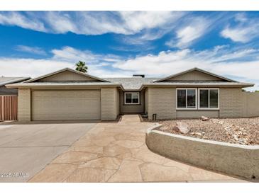 Charming single-story home featuring a stone walkway and a spacious two-car garage at 5101 E Toniko Dr, Phoenix, AZ 85044