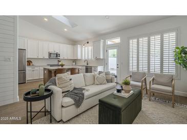 Bright and airy living room with skylight, white walls, comfortable seating, and open concept kitchen access at 7297 E Black Rock Rd, Scottsdale, AZ 85255