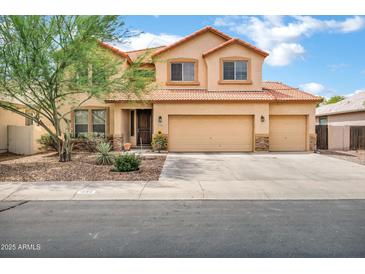 Charming two-story home featuring a tile roof, three-car garage, and low maintenance desert landscaping at 1565 E Prickly Pear Pl, Casa Grande, AZ 85122