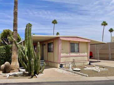 Charming mobile home with well-maintained landscaping and covered parking on a beautiful day at 318 S Crismon Rd # 65, Mesa, AZ 85208