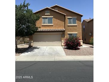 Two-story home featuring an attached two-car garage and low maintenance landscaping at 40246 W Hopper Dr, Maricopa, AZ 85138