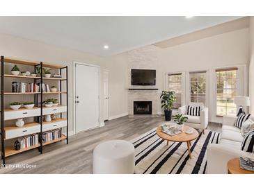 Bright living room features a decorative fireplace, modern furnishings, and ample natural light at 4901 S Calle Los Cerros Dr # 220, Tempe, AZ 85282