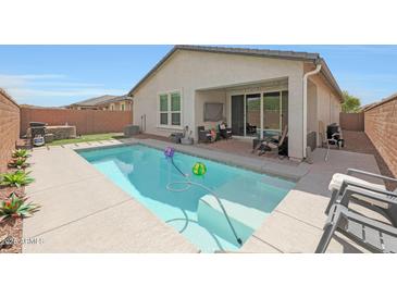 Relaxing backyard pool with patio and outdoor seating offers a perfect retreat at 8683 S 165Th Ave, Goodyear, AZ 85338