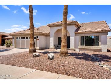 Charming single-story home featuring a tile roof, arched entryway, desert landscaping, and an attached two-car garage at 1320 E Scott Ave, Gilbert, AZ 85234