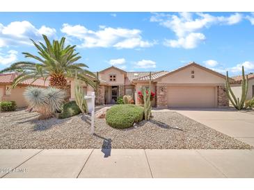 Lovely single-Gathering home featuring desert landscaping, a two-car garage, and a lush, green lawn at 15534 W Big Sky Dr, Surprise, AZ 85374